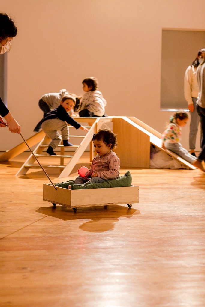 Famílias a participar em experiência sensorial de arte para bebés.